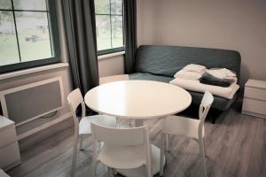 a small room with a table and chairs and a couch at Centrum Żeglarskie Domki Kempingowe in Szczecin