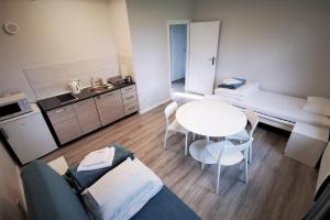 a small living room with a table and a kitchen at Centrum Żeglarskie Domki Kempingowe in Szczecin +20 photos