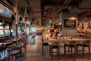 a restaurant with tables and chairs and a bar at 25hours Hotel beim MuseumsQuartier in Vienna