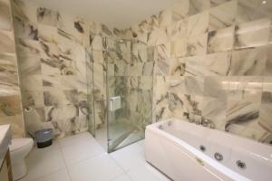 bagno con vasca, doccia e servizi igienici di The Guest Hotel & Spa a Port Dickson