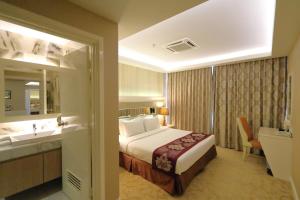 una camera d'albergo con un letto e un bagno di The Guest Hotel & Spa a Port Dickson