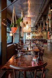 a restaurant with wooden tables and chairs and chandeliers at 25hours Hotel beim MuseumsQuartier in Vienna