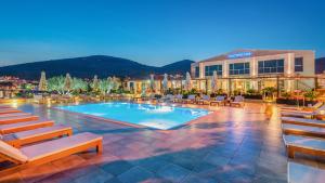 a hotel with a swimming pool with chairs and a building at Marina Baotić Apartments in Trogir