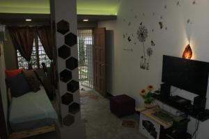 een kamer met een woonkamer met een televisie en een woonkamer met een kamer bij The Retreat Homestay in Tanjung Malim