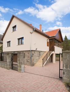 維謝格拉德的住宿－Harangvirág Apartmanház - Visegrád，一座带砖瓦车道的大型白色房屋