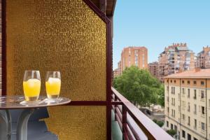 two glasses of orange juice on a table on a balcony at San Pietro Home La Rioja in Logroño