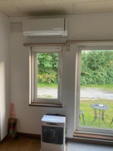 a room with two windows with a table and a table at Furano Rental House in Furano +14 photos
