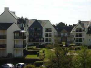 a row of apartment buildings with cars parked in a yard at REF 204 Appartement pour six personnes situé entre port Crouesty et la plage ARZON in Arzon +7 photos