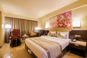 a hotel room with a large bed and a desk at Sai Palace Grand, Malad in Mumbai +46 photos