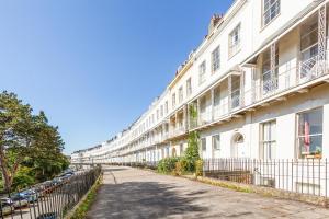 um edifício branco com uma cerca ao lado de uma rua em Elegant Period Clifton Balcony Apt - Simply Check In em Bristol