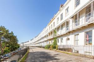 a white building with a fence next to a street at Elegant Period Clifton Balcony Apt - Simply Check In in Bristol