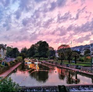 a river with boats in it under a cloudy sky at The Blenheim in Dawlish