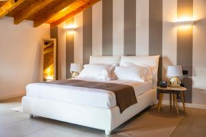 um quarto com uma grande cama branca com paredes listradas em Casa Ananda em Ferno