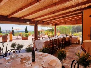 un comedor con mesas y sillas y copas de vino en Agriturismo Isola Verde, en Cerreto Guidi