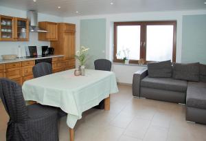 a kitchen and living room with a table and a couch at Ferienwohnung Roderath in Nettersheim