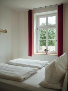 two beds in a room with a window at Hotel Garni Ammergauer Hof in Oberammergau