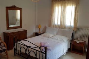 a bedroom with a bed with a mirror and a dresser at Koulas House in Diava in Kalabaka