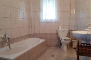 a bathroom with a tub and a toilet and a sink at Koulas House in Diava in Kalabaka