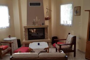 Koulas House in Diava في كالامباكا: غرفة معيشة مع أريكة ومدفأة