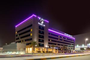 a building with purple lights on top of it at Premier Inn Abu Dhabi International Airport in Abu Dhabi