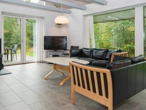 ein Wohnzimmer mit einem Sofa und einem Tisch in der Unterkunft 4 star holiday home in Rømø in Mølby
