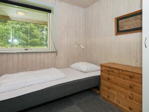 ein kleines Schlafzimmer mit einem Bett und einem Fenster in der Unterkunft 4 star holiday home in Rømø in Mølby