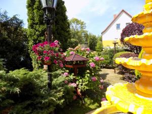 a garden with flowers and a street light at Pensjonat Angela in Łeba