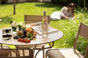 a table with a bottle of wine and a plate of food at Villa du Pyla in Pyla-sur-Mer