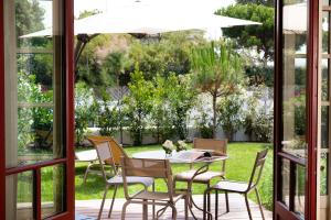 a dining room with a table and chairs on a patio at Villa du Pyla in Pyla-sur-Mer