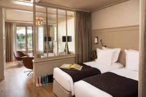 a hotel room with two beds and a mirror at Villa du Pyla in Pyla-sur-Mer