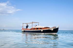 a man standing on a boat in the water at Villa du Pyla in Pyla-sur-Mer