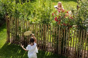 a little girl is looking at a woman behind a fence at Villa du Pyla in Pyla-sur-Mer