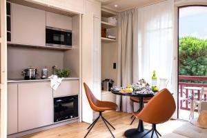 a kitchen and living room with a table and chairs at Villa du Pyla in Pyla-sur-Mer