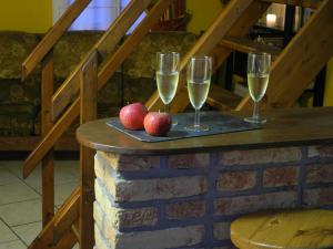 two glasses of wine and two apples on a table at Gite Rural Entre Terre et Mer in Widehem