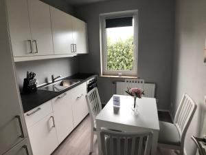 a kitchen with a white table and a table and a window at Sanierte 2-Zimmer Wohnung in strandnähe in Kiel
