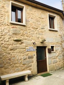 a stone building with a bench in front of it at Casa Arteleira in Padrón