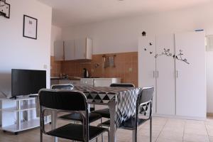 una sala da pranzo con tavolo e sedie e una cucina di Apartments Niko a Trogir