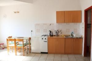 cocina con nevera blanca y mesa con sillas en Apartments Niko, en Trogir