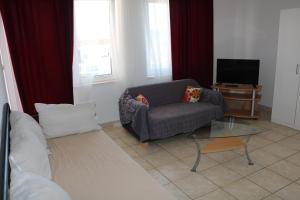 sala de estar con silla y TV en Apartments Niko, en Trogir