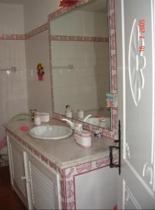 um banheiro com uma pia e um espelho grande em Casa da Figueira Velha em Resende