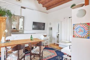 un soggiorno con tavolo, sedie e TV di Solemar Sicilia - Casa Olivia a Santa Flavia