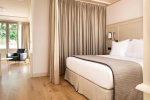 a hotel room with a large bed and a chair at Villa du Pyla in Pyla-sur-Mer