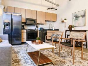 uma cozinha com electrodomésticos de aço inoxidável e uma sala de estar em Modern Downtown Loft on Gay St em Knoxville