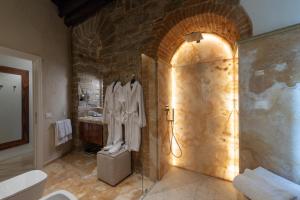 a bathroom with a shower and a stone wall at Donati Luxury Tower Suites in Florence