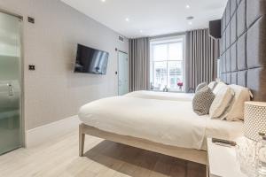 a bedroom with a large bed and a flat screen tv at The Inn on the Mile in Edinburgh