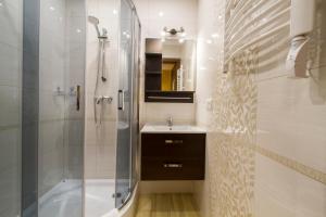 a bathroom with a shower and a sink and a tub at udanypobyt Apartamenty Przy Dolinach A i B in Kościelisko