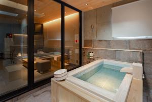 a bathroom with a jacuzzi tub and a sink at MATERIAL Fuchomae in Kyoto