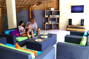 a woman and a child sitting in a living room at Santai Villa in Kuta Lombok