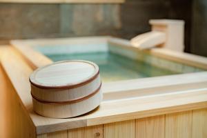 a hot tub with a wooden container sitting on top of it at MATERIAL Fuchomae in Kyoto
