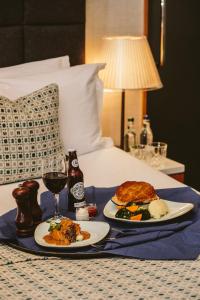 a table with two plates of food on a bed at The Inn on the Mile in Edinburgh